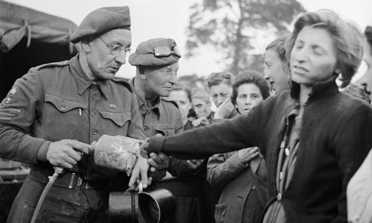 A British soldiers sprays DDT (to combat insect-born typhus) on a recently liberated female prisoner from the Bergen-Belsen concentration camp while others wait in line behind her, near the towns of Bergen and Calle, Germany, May 1945. (Photo by George Rodger/The LIFE Picture Collection/Getty Images)